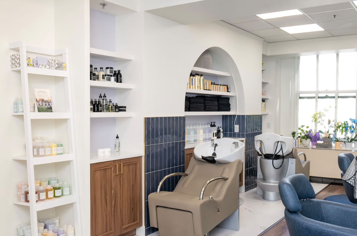 Level Headed's wash station, built into an arched wall niche with a navy tile backsplash